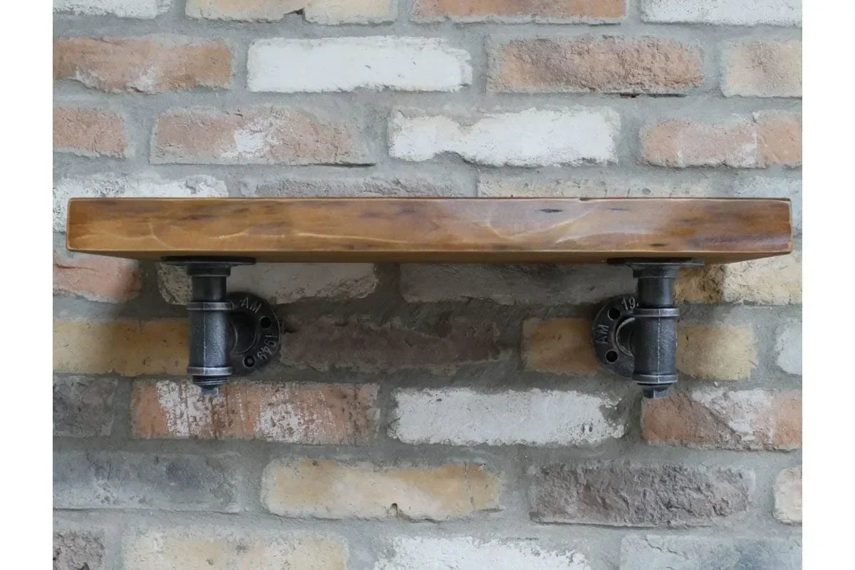 Industrial wall shelf with wood plank and black metal pipe brackets on brick wall