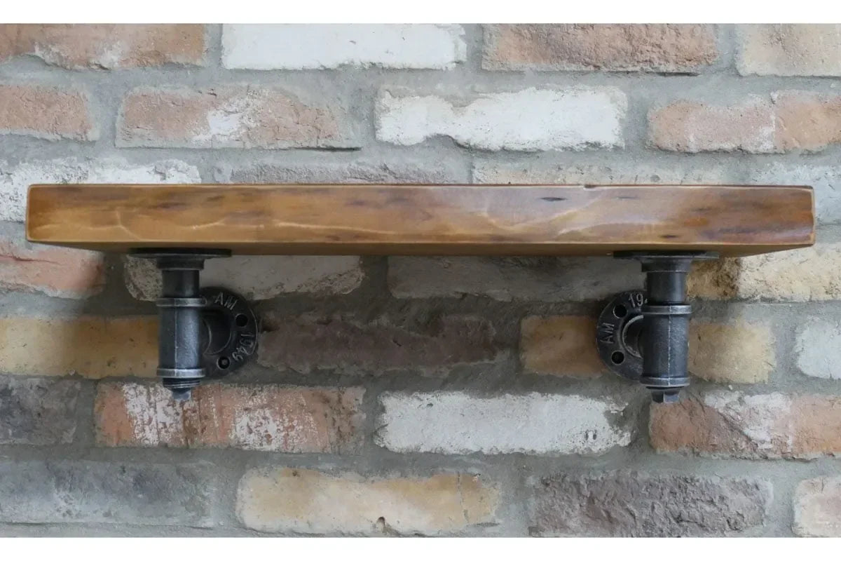 Industrial wall shelf with wood top and black metal pipe brackets on brick wall