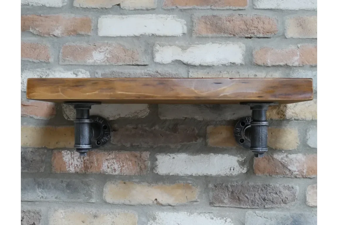 Industrial wall shelf with dark wood and black metal pipe brackets on brick wall