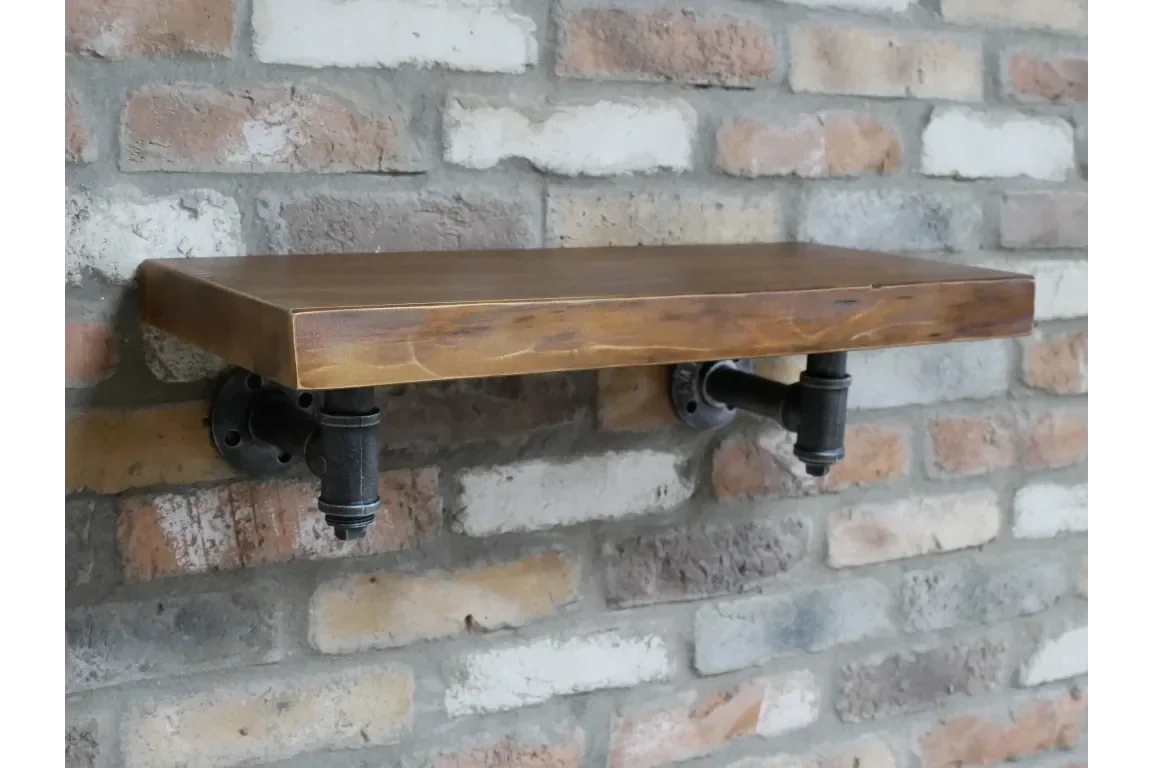 Industrial wooden wall shelf with black pipe brackets mounted on exposed brick wall