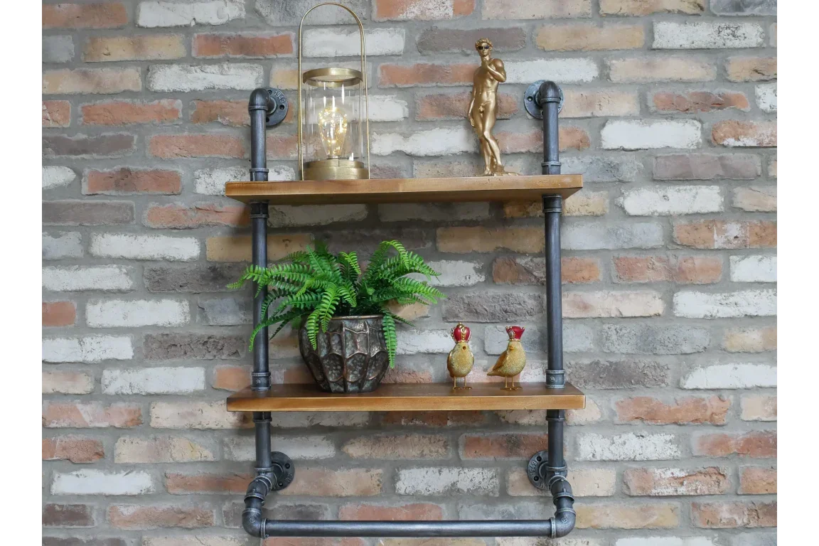 industrial pipe wall shelf with wooden boards holding decor against exposed brick wall