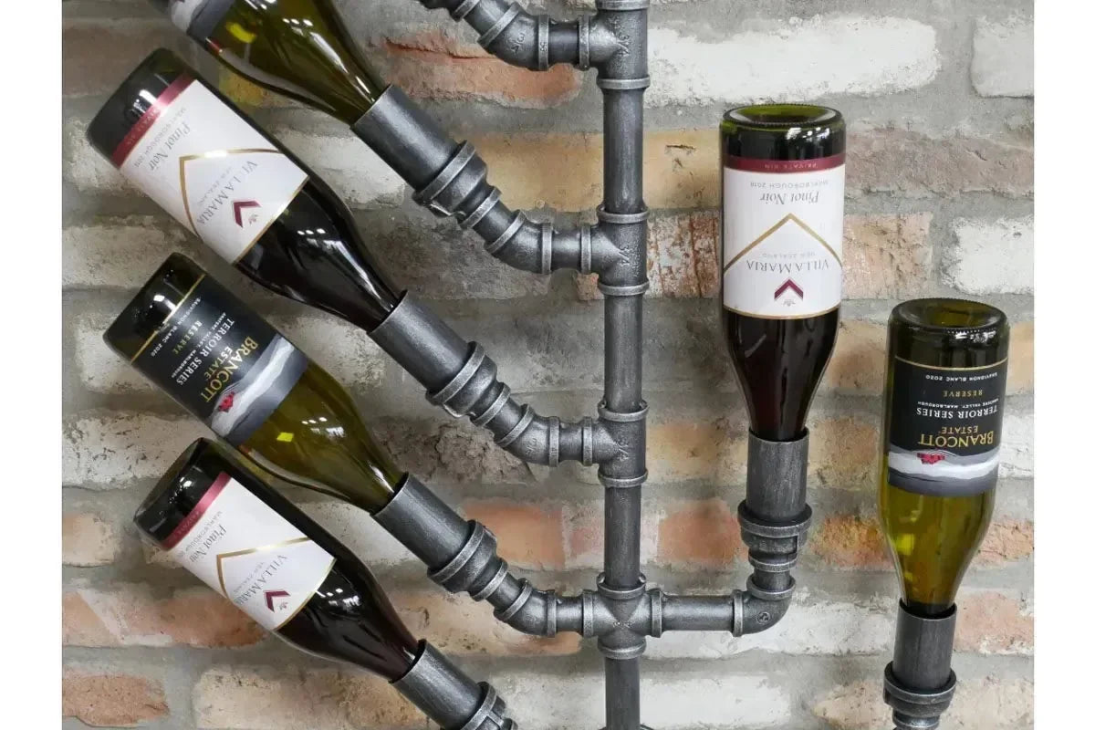 Industrial pipe wall-mounted wine rack holding six bottles against exposed brick wall