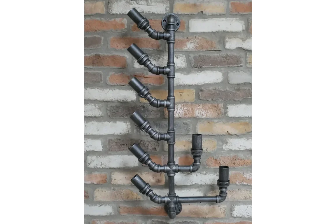 Industrial black metal pipe wall wine rack with six bottle holders on exposed brick wall