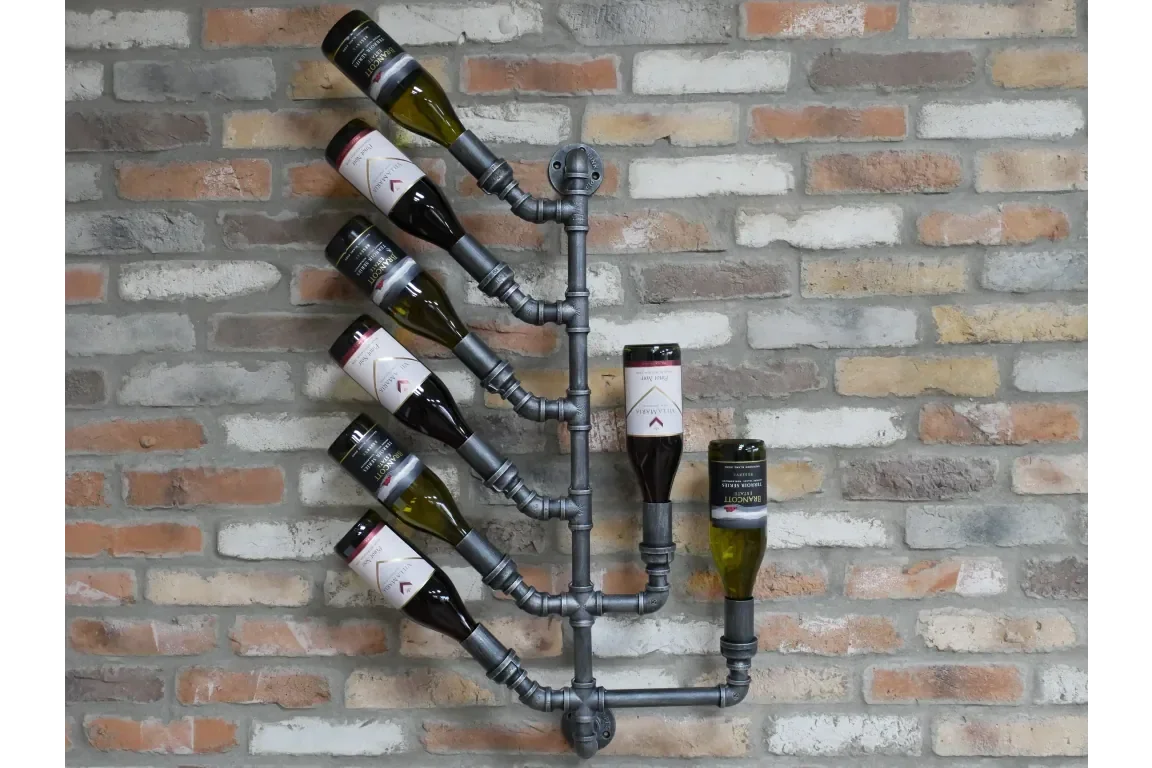 Industrial pipe wall wine rack holding seven wine bottles on exposed brick wall