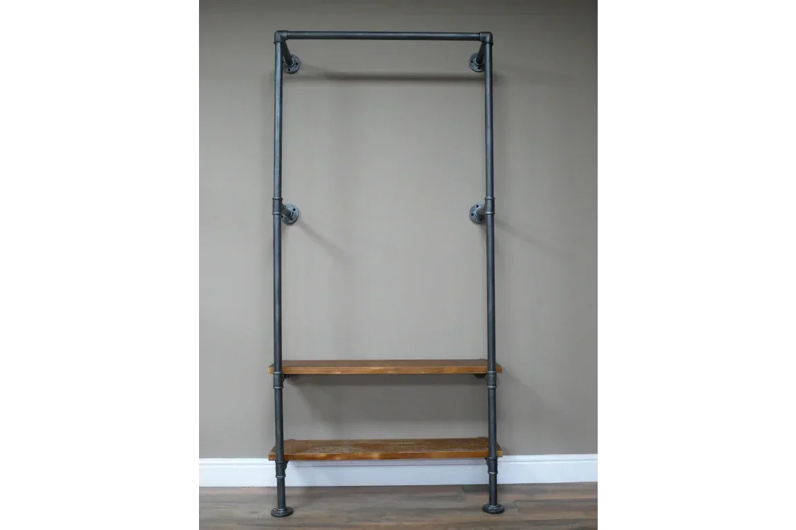 Industrial clothes rail with two wooden shelves and black metal frame against neutral wall