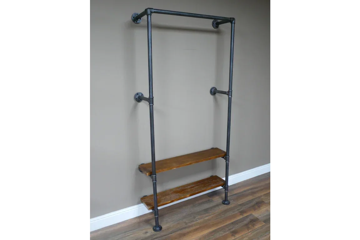 Industrial pipe clothes rail with two wooden shelves against a taupe wall