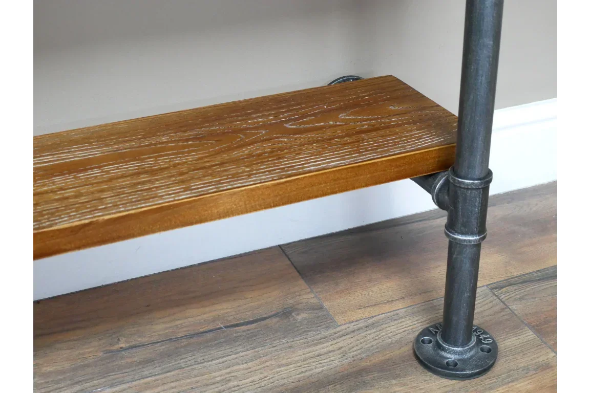 Industrial style wooden shelf with black metal pipe bracket against wall