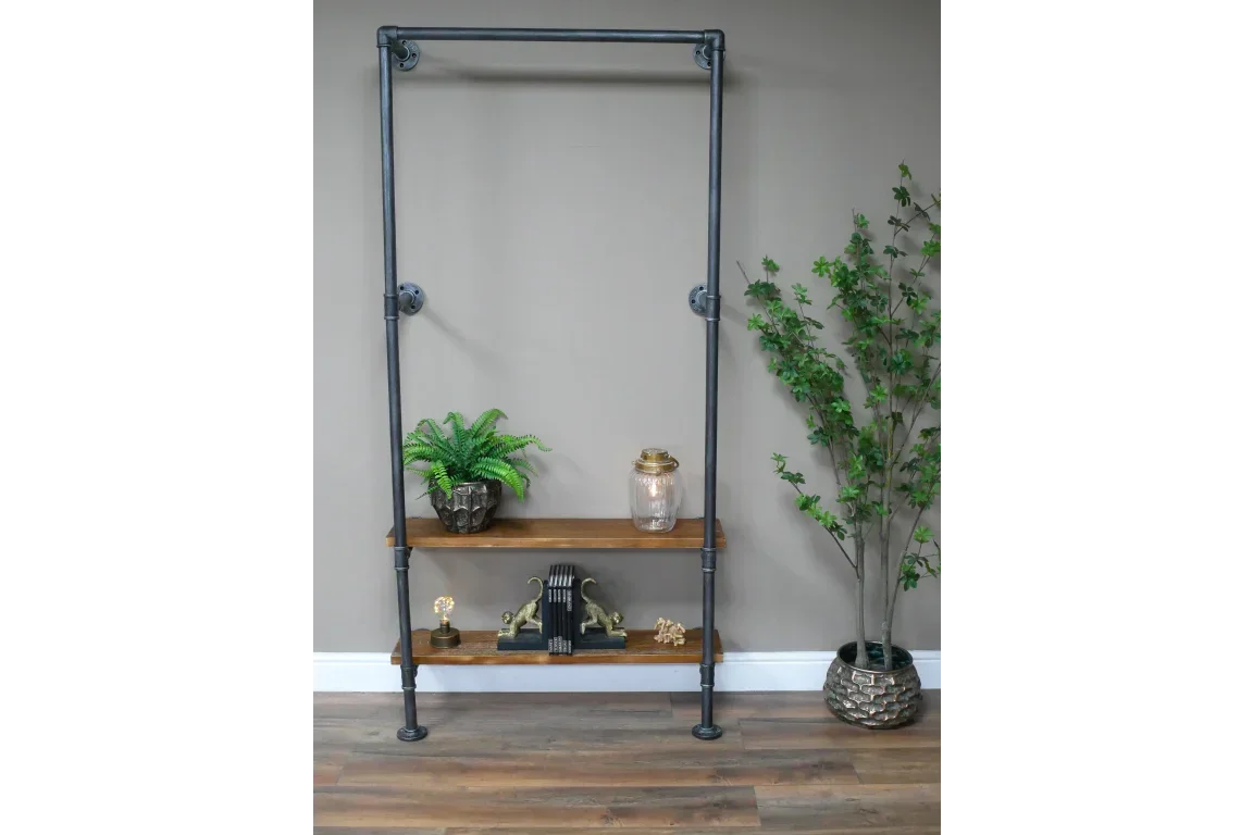 Industrial clothes rail with two wooden shelves, styled with plants and decor against wall