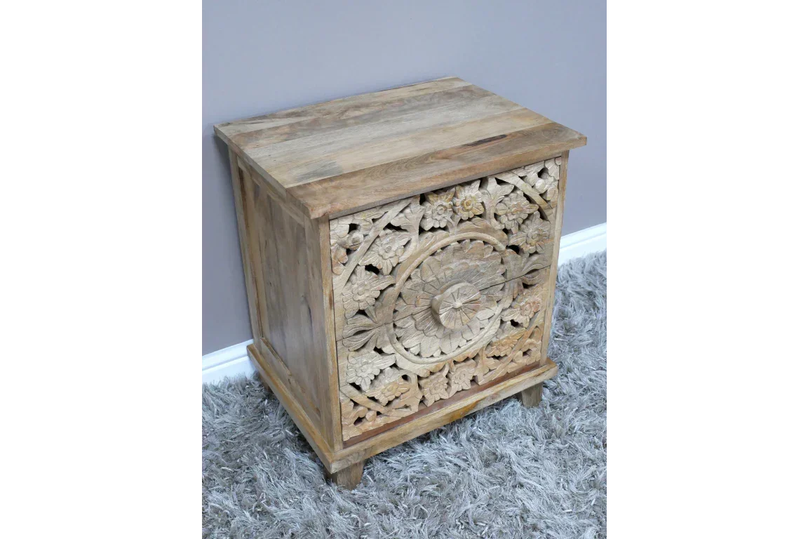 Carved wooden bedside table with ornate floral design and two drawers on grey carpet