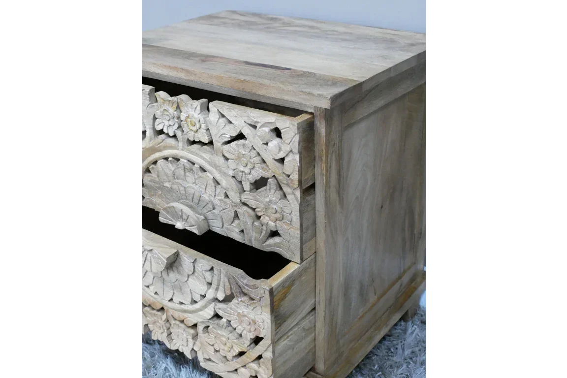 Carved wooden bedside table with floral drawer fronts and natural wood finish