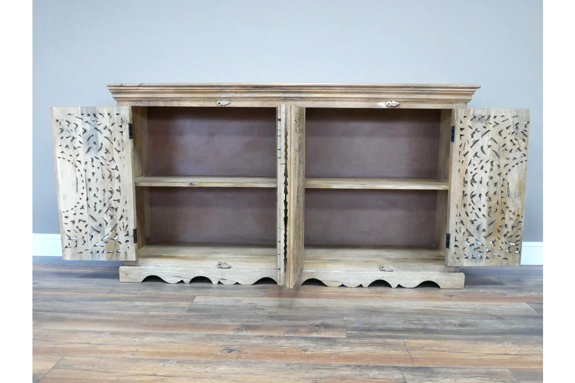 Rustic wooden sideboard with carved doors and open shelving on wooden floor