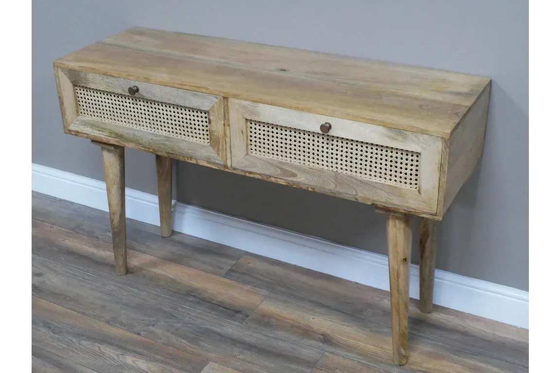 Wood console table with cane front drawers and slim legs on wood flooring