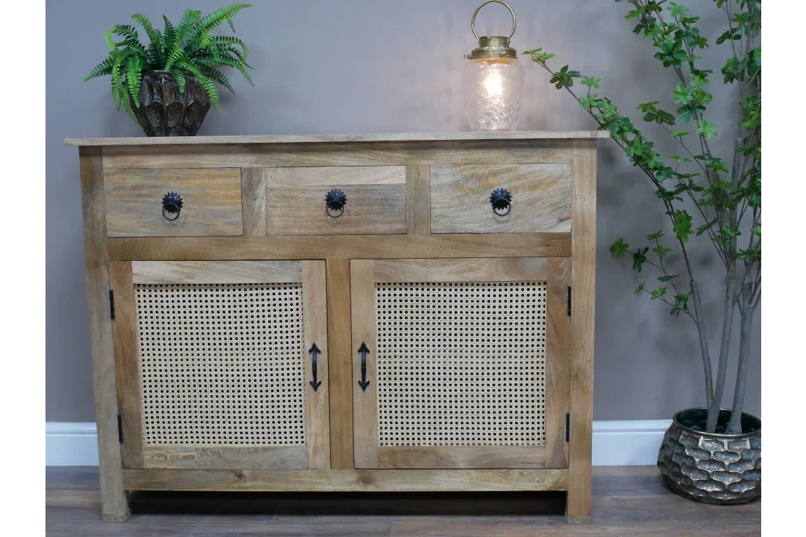Wooden sideboard with three drawers, rattan cupboard doors, and black handles in living room