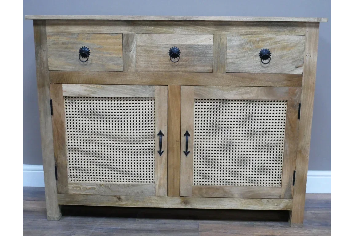 Wooden sideboard with rattan doors, three drawers, and black metal handles on hardwood floor