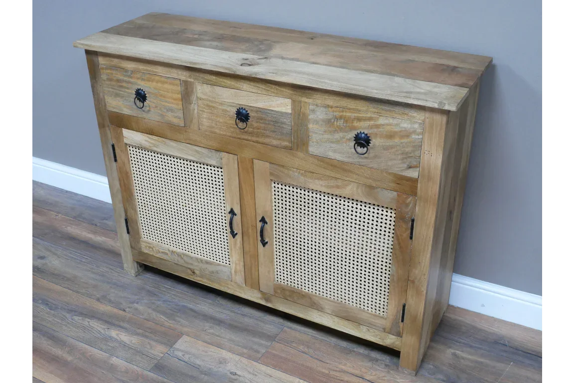 Oak sideboard with three drawers and two cane panel doors against grey wall