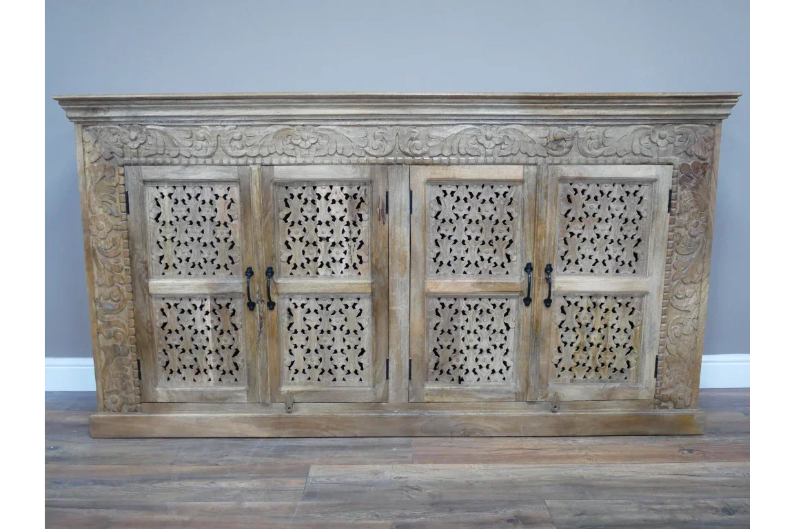 Solid wood sideboard with carved floral panels and four doors on wooden flooring