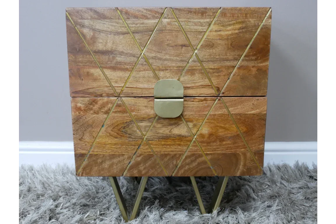 Wooden bedside table with gold geometric detail and metal legs on grey rug