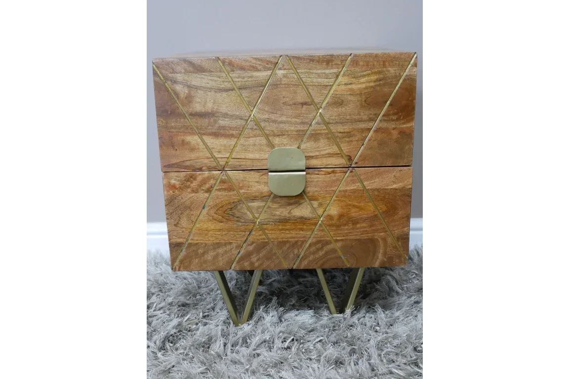 Wooden bedside table with gold geometric pattern and metal legs on textured grey rug