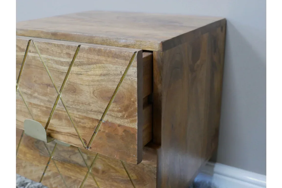 Wooden bedside table with brass inlay detail and open drawer against a grey wall