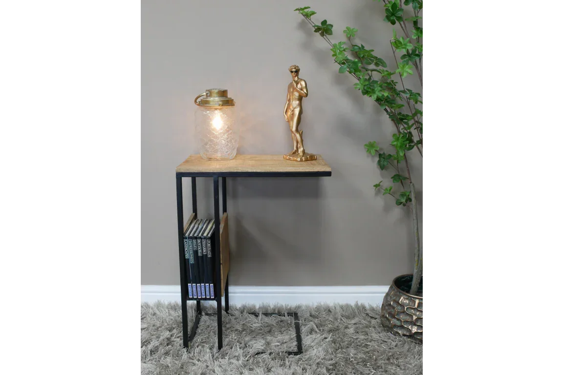 Industrial side table with black metal frame, wood top, lamp, and books on lower shelf