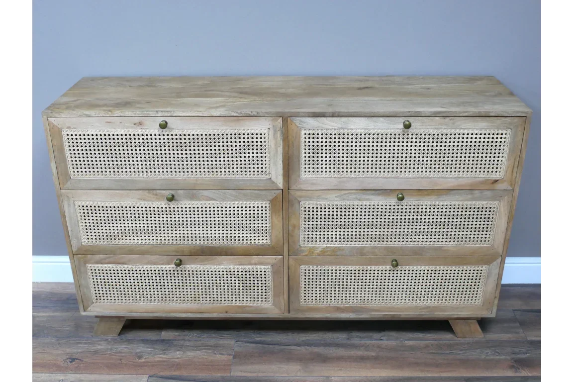 Mango wood chest of drawers with six cane front panels on wooden floor