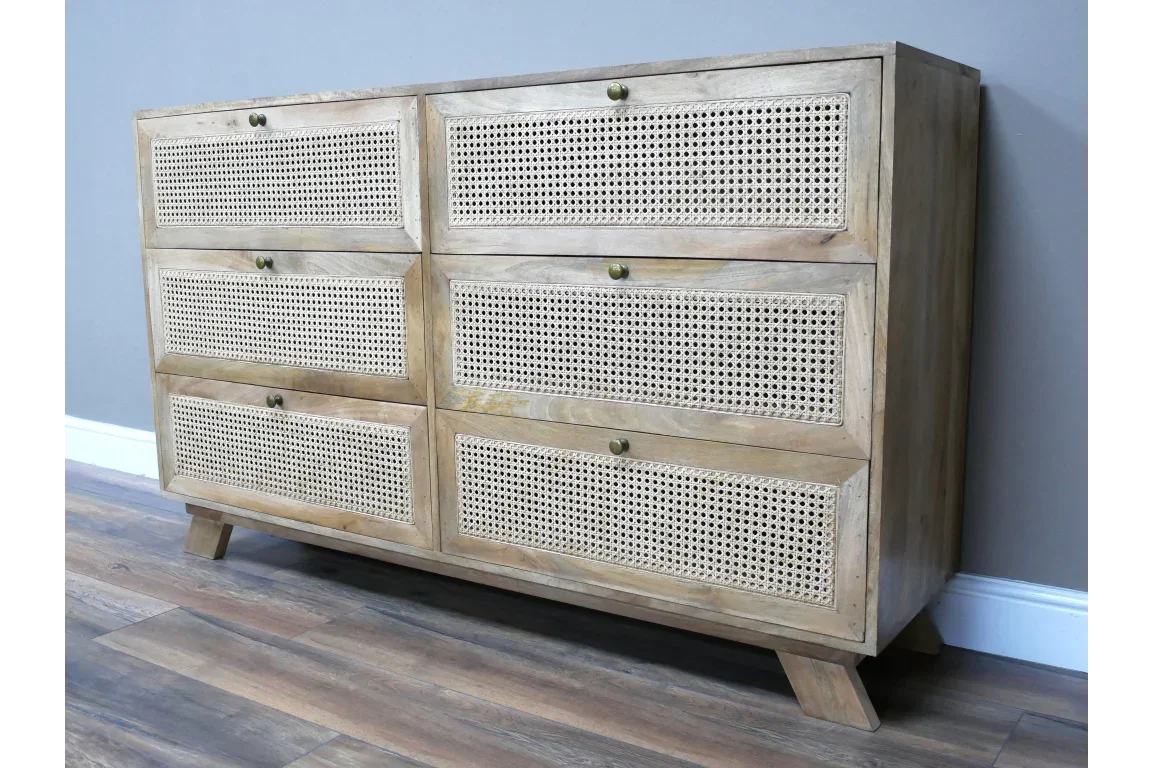 Wooden chest of drawers with six rattan front panels and angled legs on hardwood floor