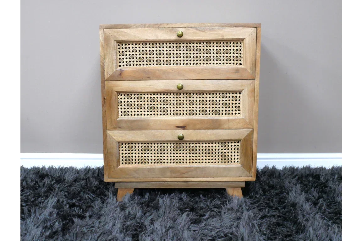 Natural wood chest of drawers with three rattan cane front panels on grey rug