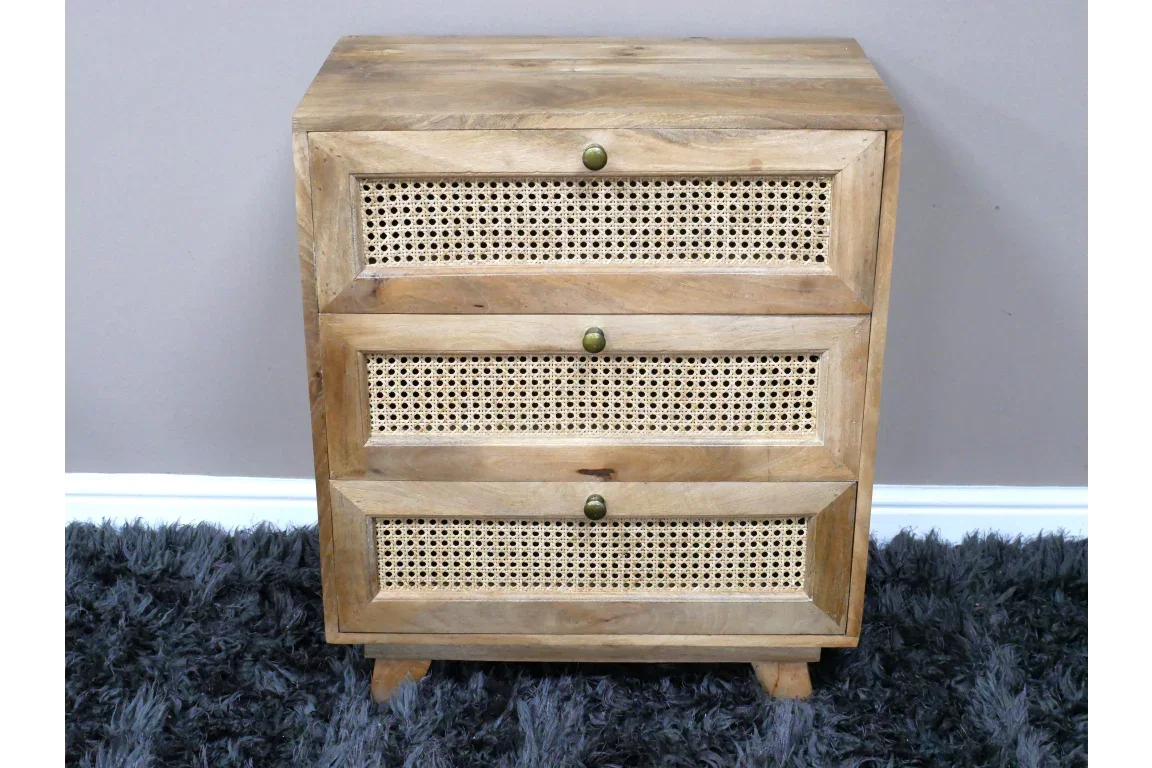 Mango wood chest of drawers with rattan fronts and brass knobs on grey rug