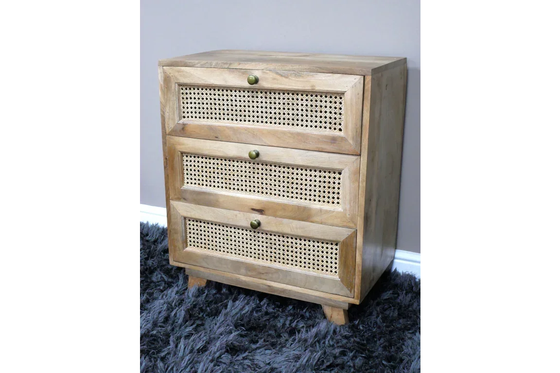 Three drawer wooden chest with rattan fronts and brass knobs on a grey rug