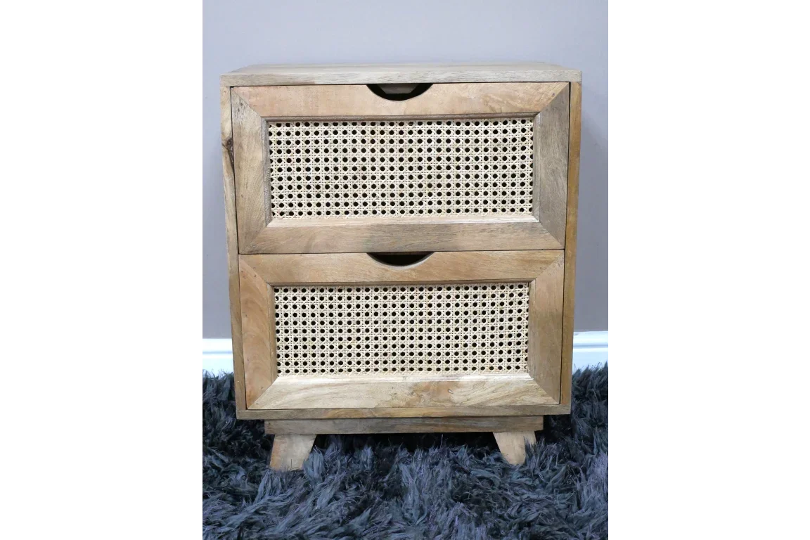 Wooden bedside table with two cane-front drawers on a dark shaggy rug