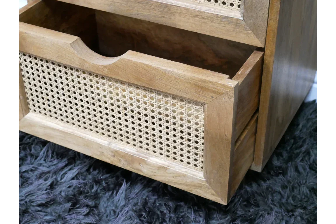 Wooden bedside table with open rattan drawer on dark textured rug