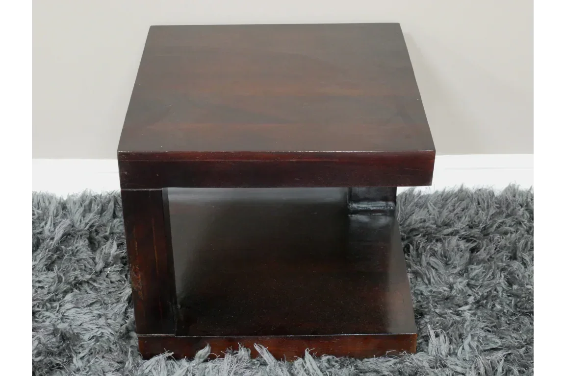 Dark wood square side table with open shelf, placed on grey shaggy rug