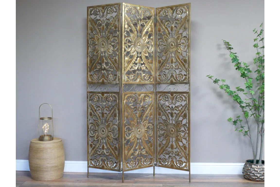 Gold metal room divider with ornate floral pattern in a modern living room setting