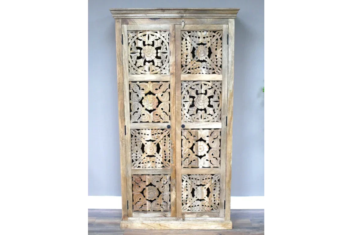 Tall wood cabinet with ornate carved doors and floral patterns on dark floor