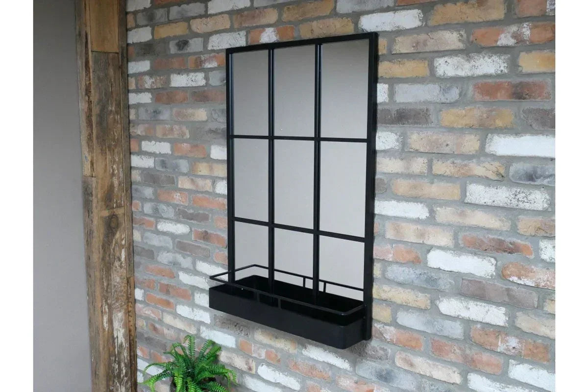 Black metal window mirror with planter box mounted on exposed brick wall