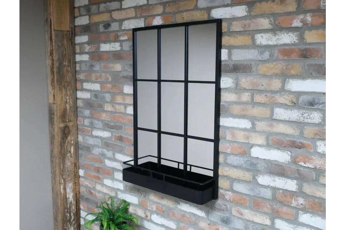 Black metal window mirror with planter box mounted on brick wall