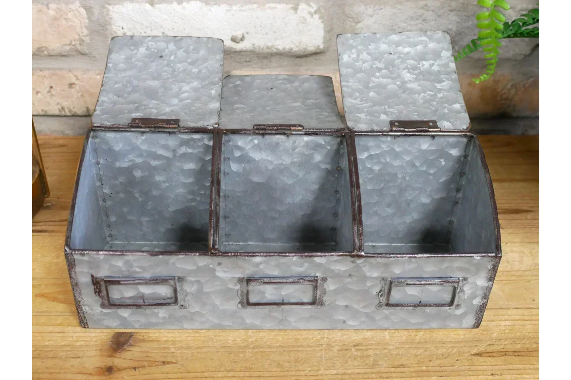 Galvanised metal storage box with three compartments and label holders on wooden surface
