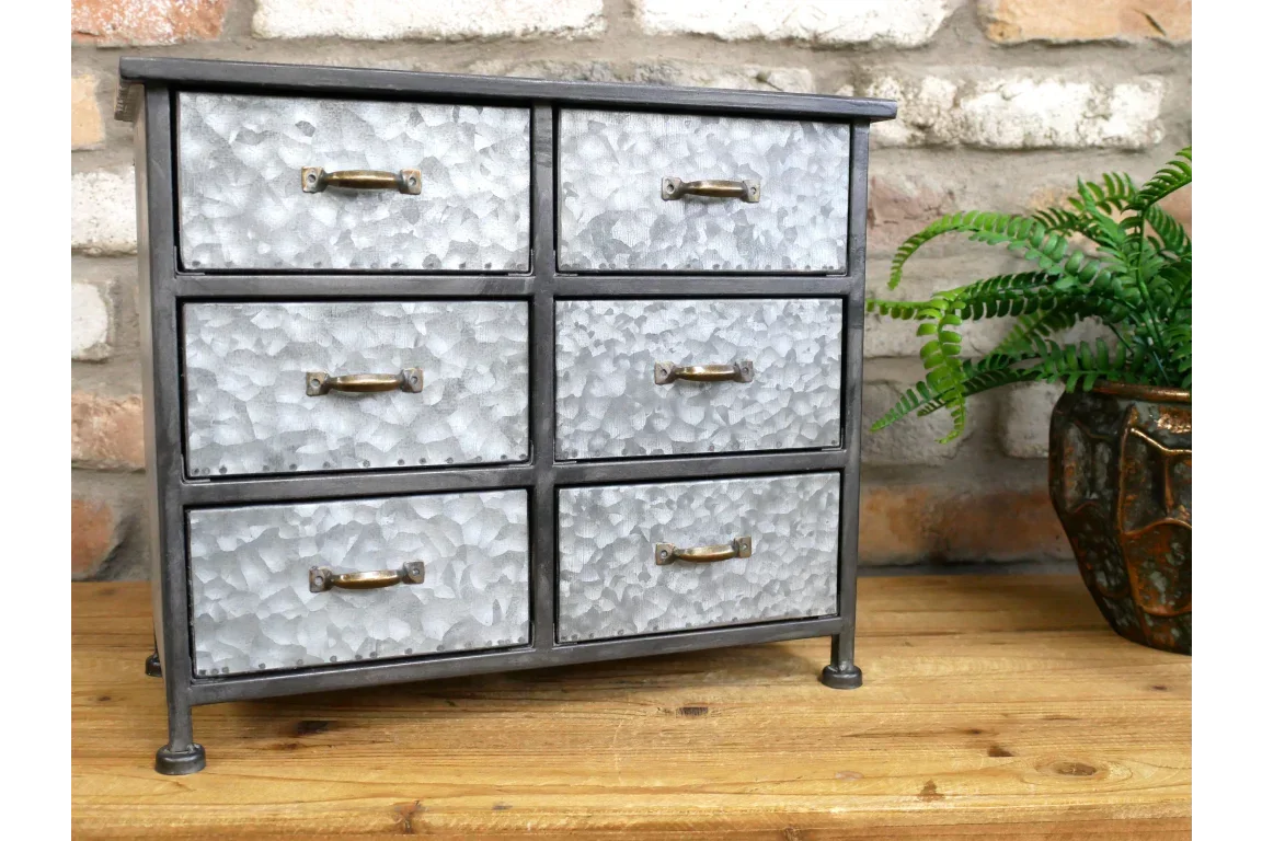 Six drawer galvanized metal storage cabinet with brass handles on wooden surface