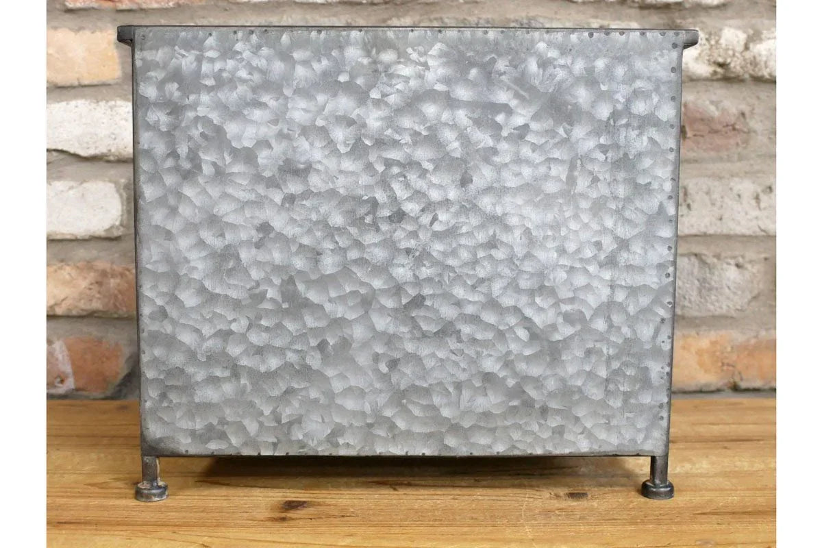 Rectangular galvanized metal planter box with textured finish on wooden surface