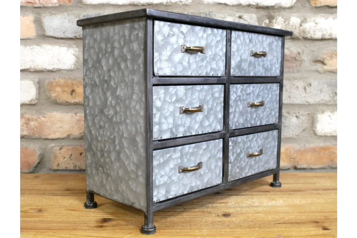 Industrial metal storage cabinet with six drawers and brass handles on wooden surface