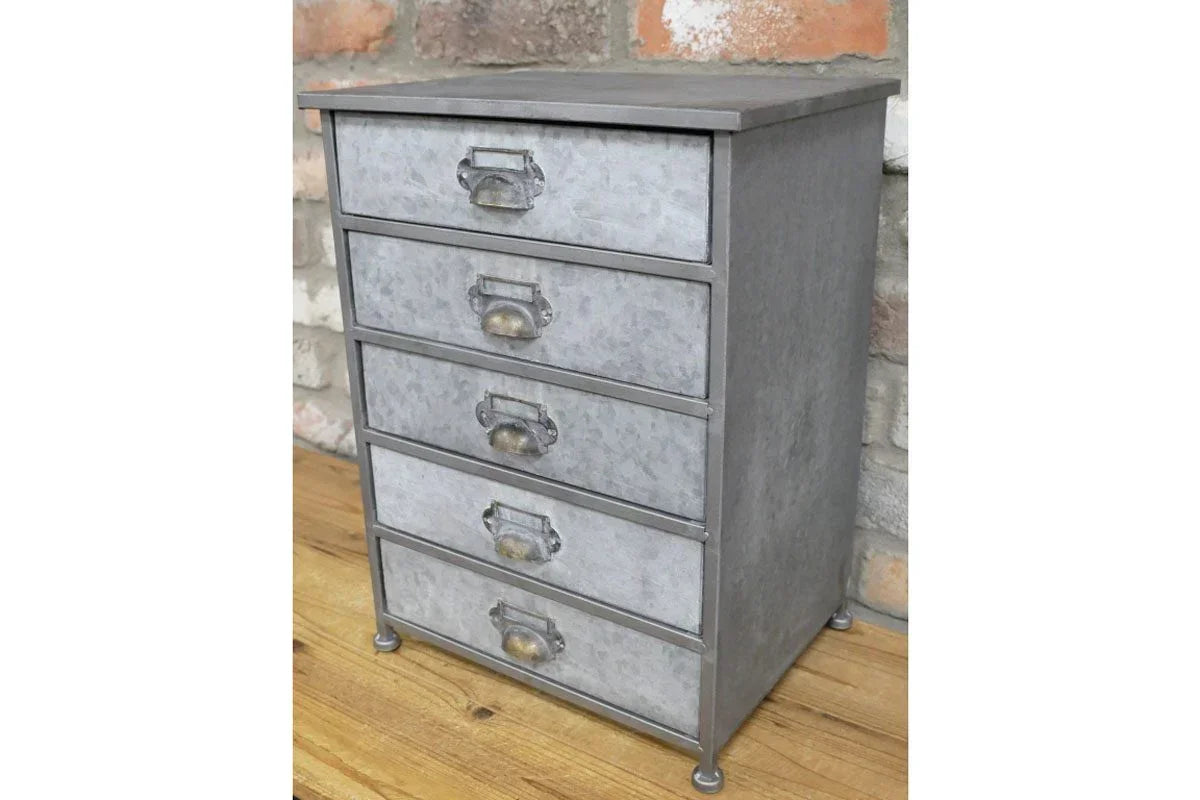 Metal storage drawers with five compartments on wooden floor against brick wall
