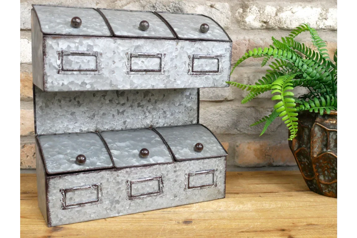 Galvanised metal storage organiser with six compartments on wooden table near plant