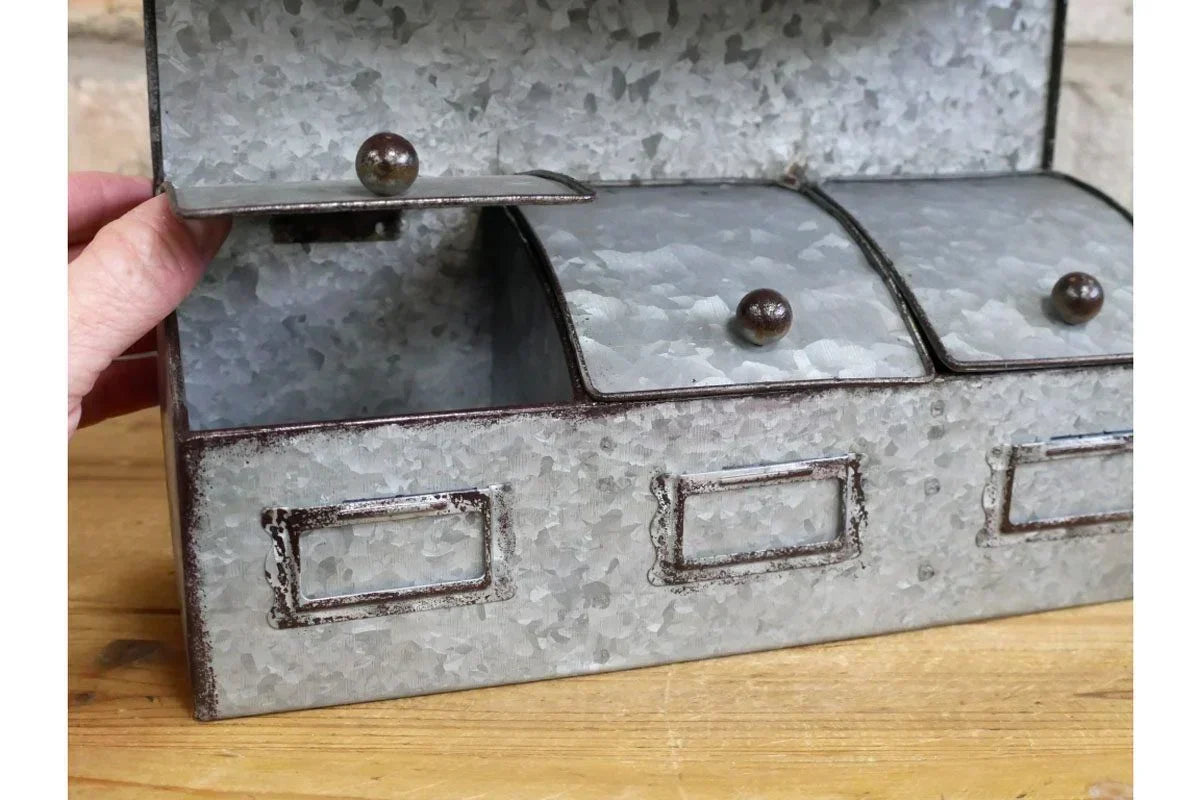 Galvanized metal storage box with three compartments and label holders on wooden surface