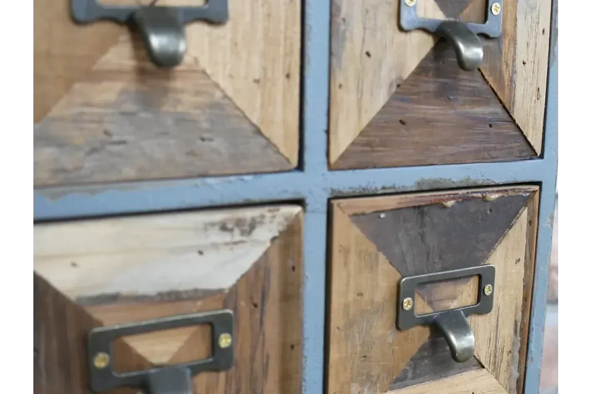Close up of rustic wooden drawers with metal handles and geometric panel design