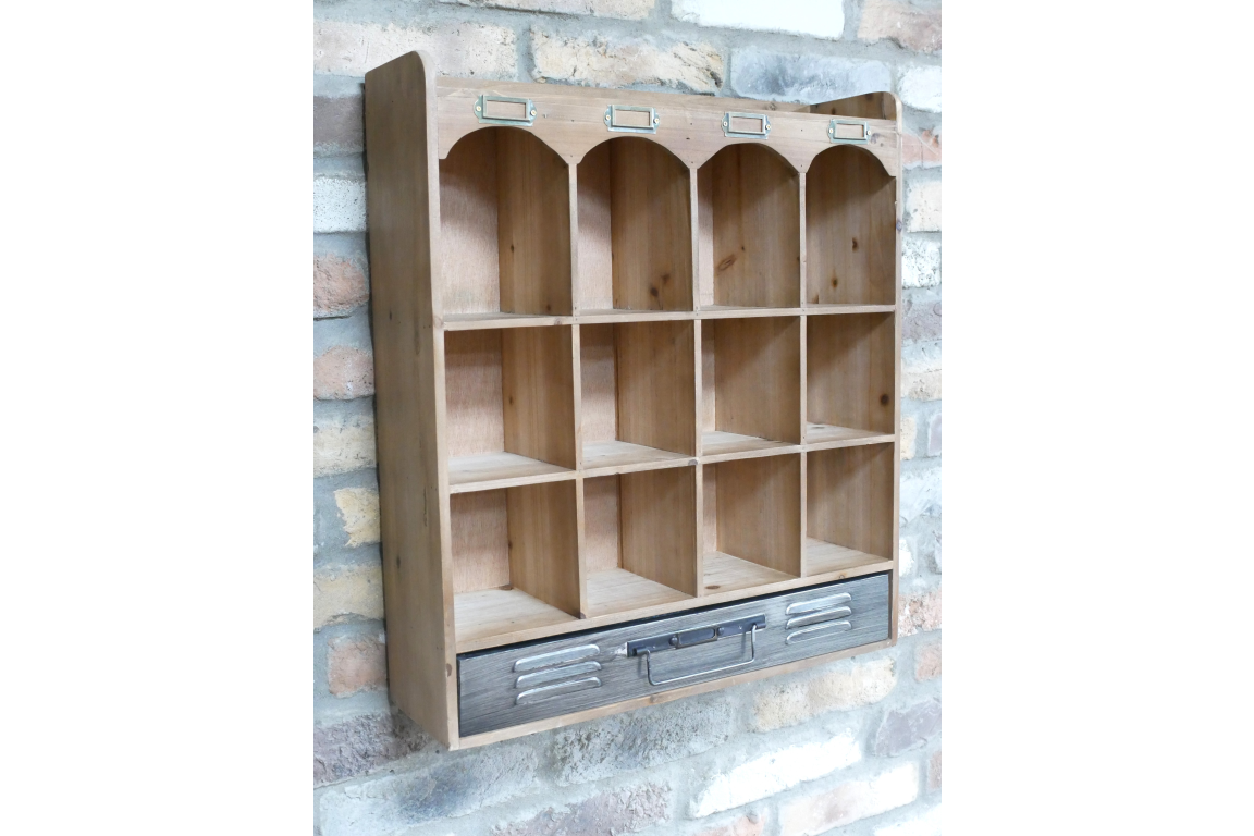 Wooden wall unit with twelve compartments and one gray drawer, shown at an angle against a brick wall background.