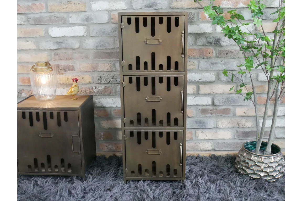 Industrial metal storage cabinet with three doors against brick wall, beside plant and lamp