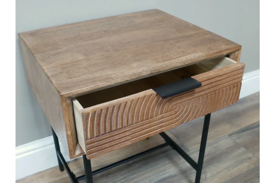 Wooden bedside table with textured drawer front and black metal legs, drawer partially open