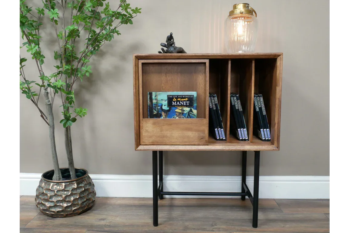 Wooden bookcase with four compartments on black metal legs, books and lamp on top
