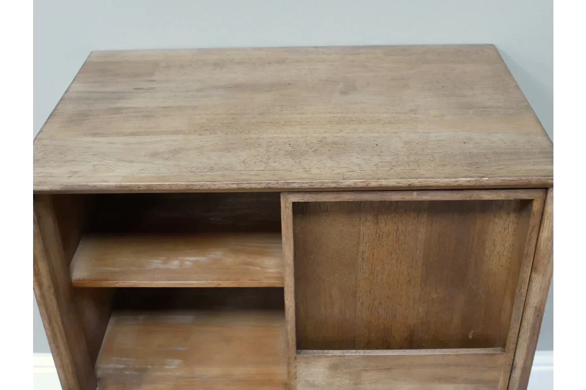 Wooden storage unit with open shelves and sliding door, close-up of top surface and compartments