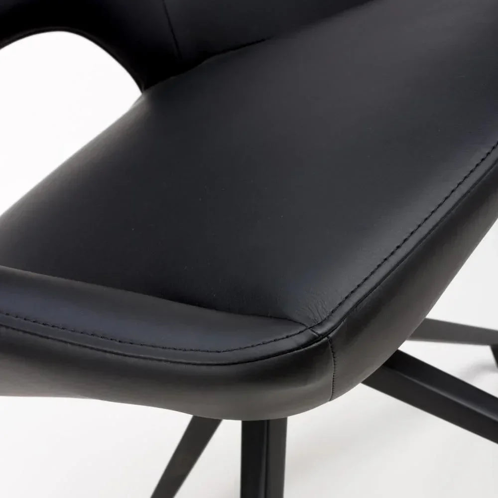 Close up of black leather dining chair seat with stitched edge and metal legs